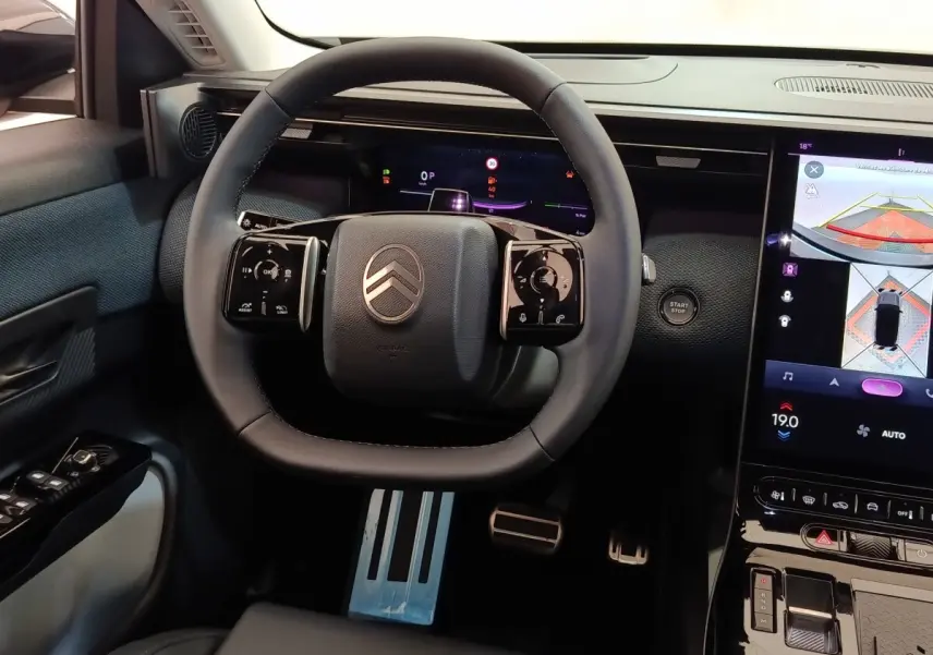 Vue intérieure centrée sur le volant cuir noir de la Citroën C5 Hybride avec écran tactile et affichage multifonctions.