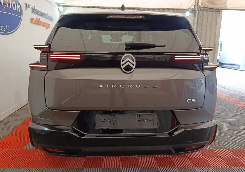 Vue arrière d'un Citroën C5 Aircross gris foncé avec feux LED horizontaux et logo centré sur hayon noir.