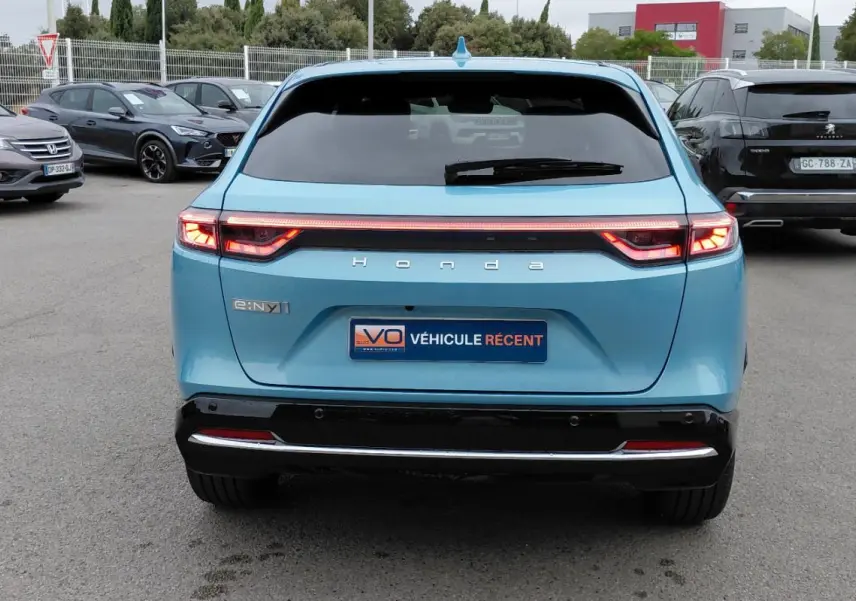 Vue arrière d'une Honda e:Ny1 Advance 204 ch bleu électrique 2025 avec feux LED et bande lumineuse continue.