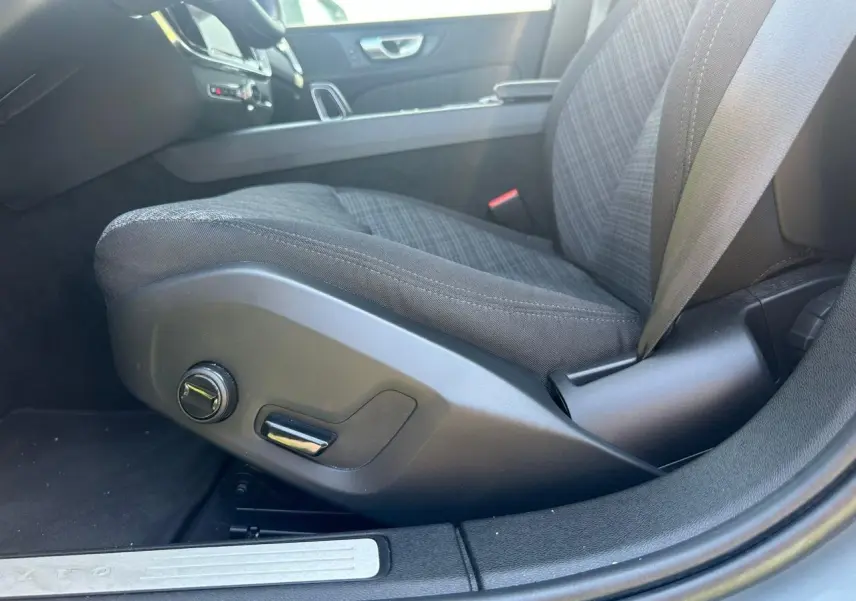 Gros plan sur le siège conducteur tissu gris avec commandes manuelles dans l'habitacle d'une Volvo S60 Thunder Grey 2024.