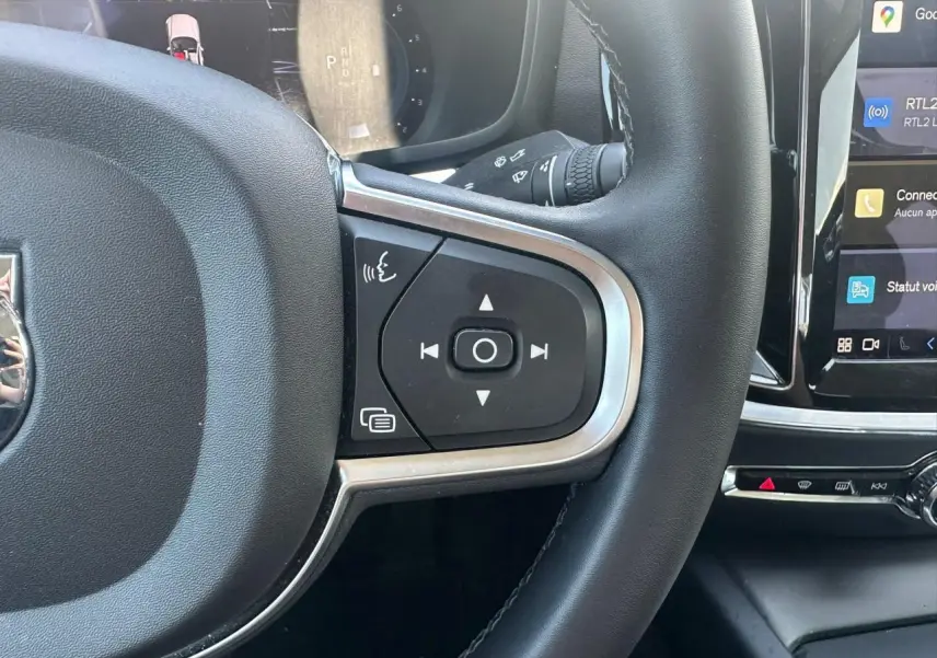 Gros plan sur le volant noir avec commandes intégrées et écran tactile du tableau de bord d'une Volvo S60 Thunder Grey 2024