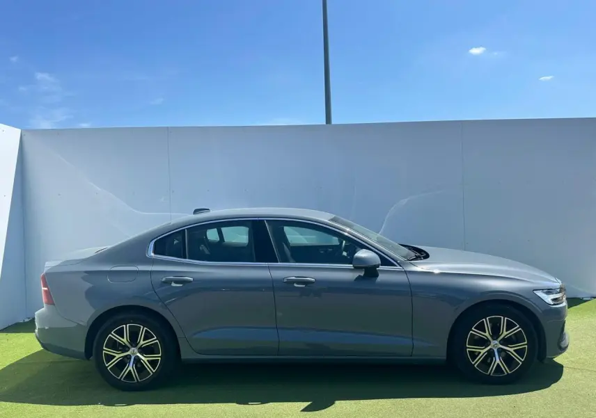 Profil côté gauche d'une Volvo S60 2024 Thunder Grey Metal avec jantes alliage 17 pouces en Y noir et diamant.