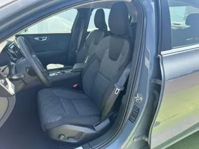 Intérieur côté conducteur d'une Volvo S60 2024 Thunder Grey Metal, siège tissu gris et volant simili-cuir visible