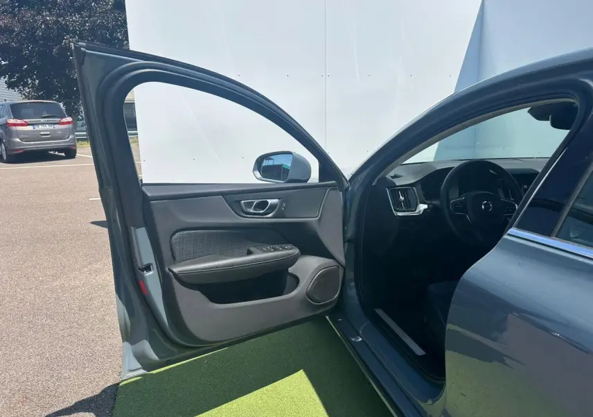 Portière avant gauche ouverte d'une Volvo S60 Thunder Grey Metal 2024, montrant l'intérieur côté conducteur.