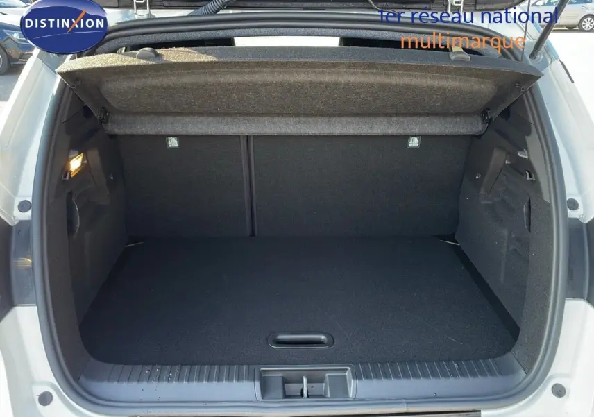 Coffre ouvert du Renault Captur E-Tech hybride blanc nacré avec toit gris, vue arrière montrant l'espace de chargement vide.