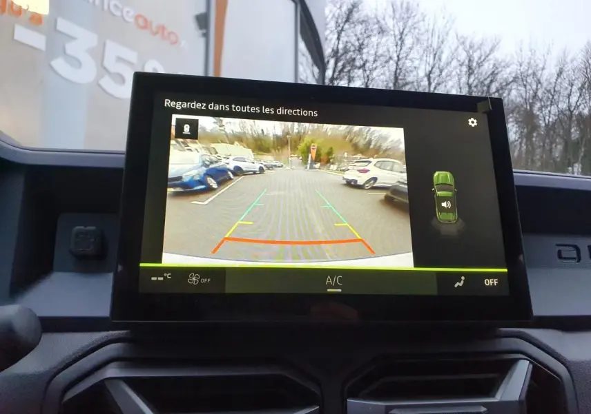 Écran central affichant la caméra de recul du Dacia Duster blanc glacier, vue intérieure du tableau de bord.