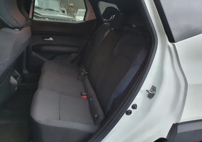 Vue côté droit de la banquette arrière noire du Dacia Duster blanc glacier avec ceinture 3 points et appuie-têtes visibles.