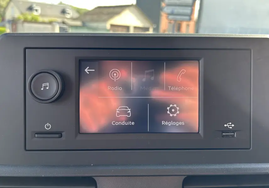 Écran tactile central du tableau de bord du DANGEL Peugeot Partner gris Artense, affichant les menus Radio, Média, Téléphone, Conduite et Réglages.