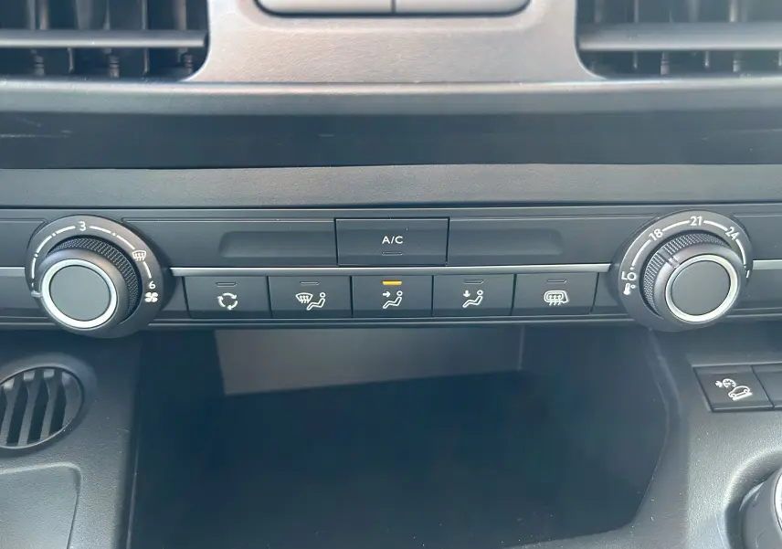Vue rapprochée de la console centrale du Peugeot Partner Dangel 4x4 avec commandes de climatisation et ventilation.