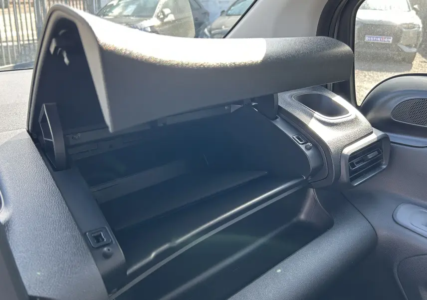 Vue intérieure rapprochée du compartiment de rangement ouvert côté passager du DANGEL Peugeot Partner gris Artense.