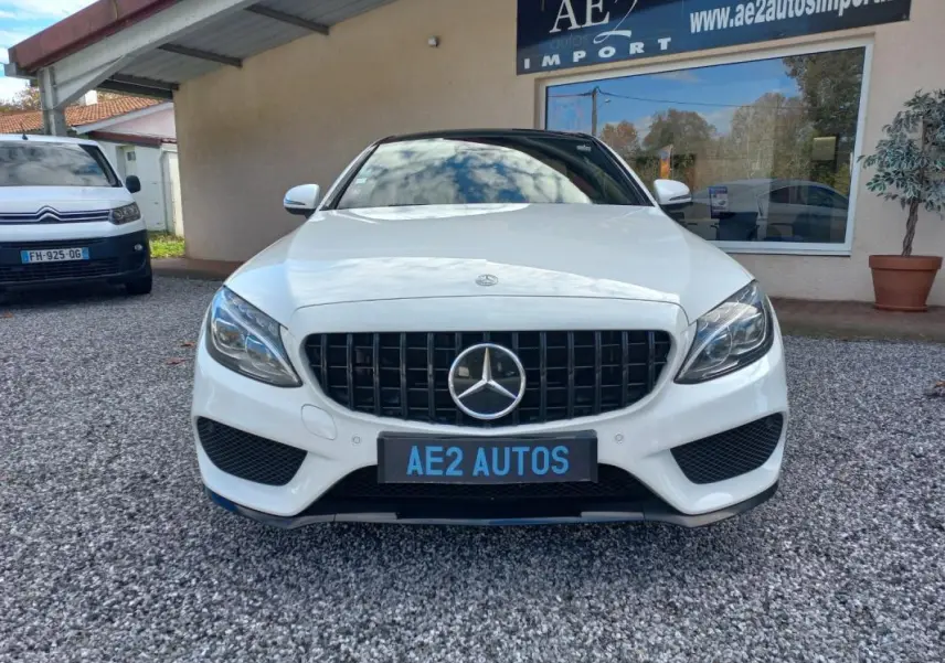 Vue de face d'une Mercedes Classe C Coupé blanc brillant avec calandre noire et logo étoile central.
