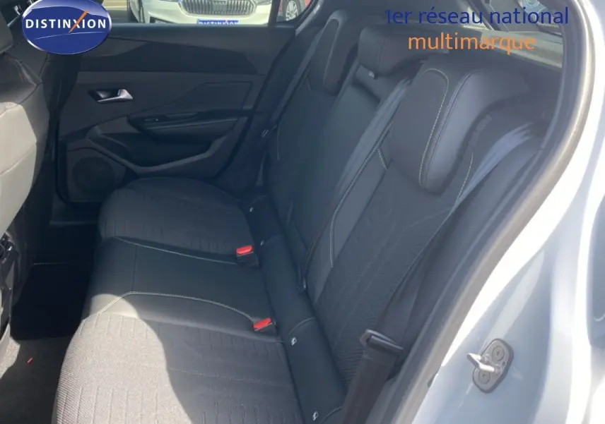 Vue intérieure côté droit des sièges arrière noirs en tissu et cuir d'une Peugeot 308 Hybrid 145ch GT blanche.