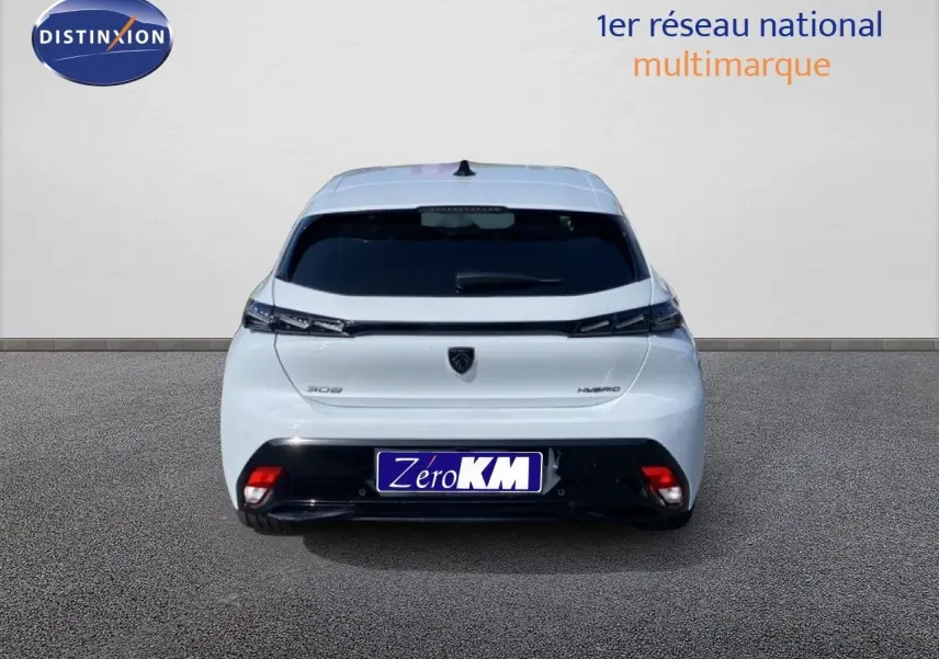 Vue arrière d'une Peugeot 308 Hybrid blanche Okenite Metal avec feux effilés et logo noir sur fond clair.