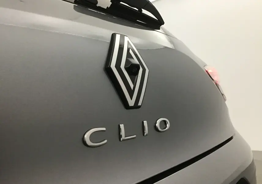 Gros plan sur l'arrière gris schiste d'une Renault Clio V, mettant en valeur le logo et la caméra de recul intégrée.