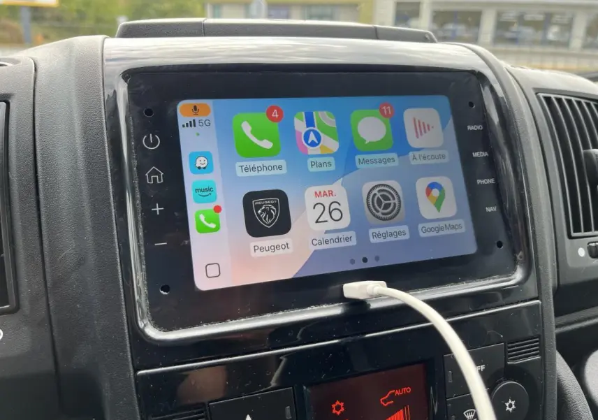 Écran tactile multimédia 7 pouces du Peugeot Boxer Fourgon blanc, avec Apple CarPlay et câble USB connecté.