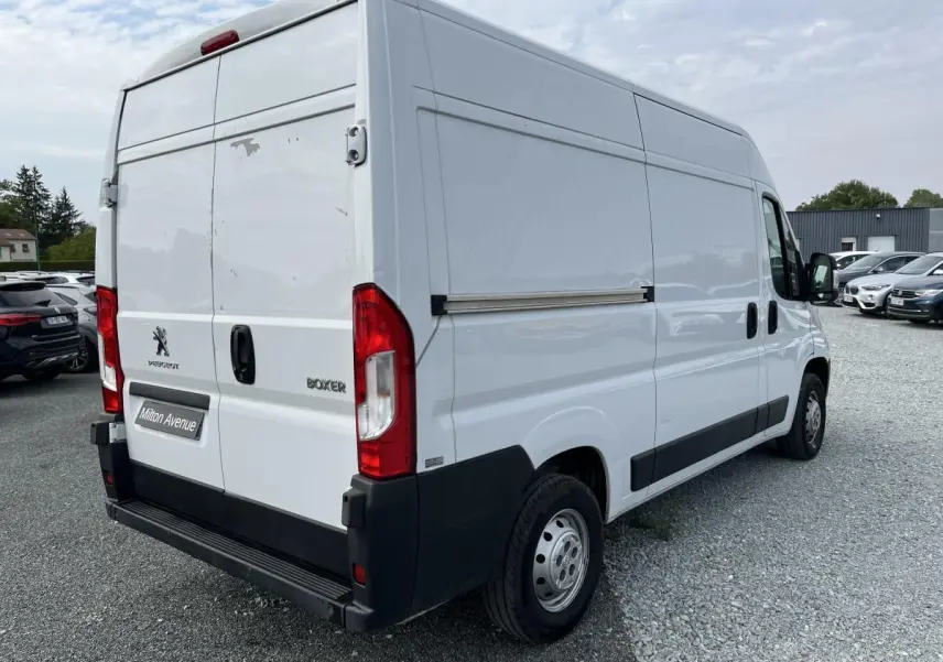 Vue 3/4 arrière droite du Peugeot Boxer Fourgon blanc avec portes arrière tôlées et porte latérale coulissante.