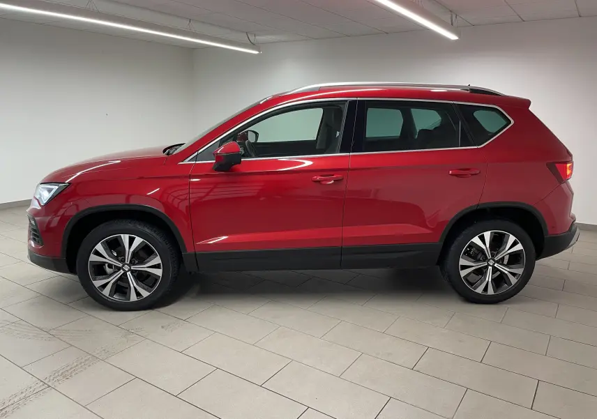 Vue de profil côté gauche du SEAT Ateca 2024 en rouge Velvet avec jantes 18 pouces usinées dans un intérieur neutre.