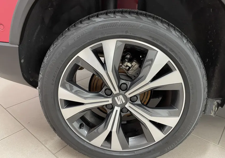 Gros plan sur la jante 18 pouces Performance usinée du SEAT Ateca Rouge Velvet, côté arrière droit du véhicule.