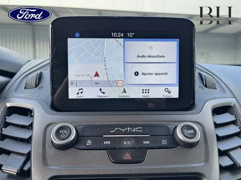 Vue rapprochée de l'écran tactile SYNC 3 du Ford Transit Connect blanc glacier, affichant la navigation et les commandes audio.