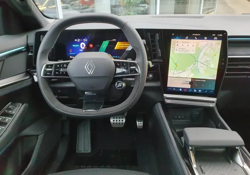 Vue intérieure avant du Renault Austral 2025, tableau de bord noir avec écran tactile vertical et volant Alcantara.