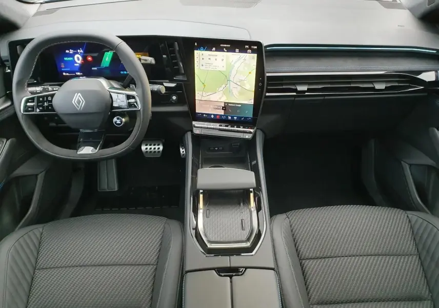 Vue intérieure avant du Renault Austral 2025, tableau de bord moderne avec écran tactile vertical et volant Alcantara noir.