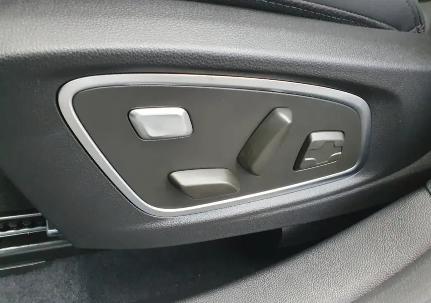 Gros plan sur les commandes électriques de réglage du siège conducteur du Renault Austral gris schiste.