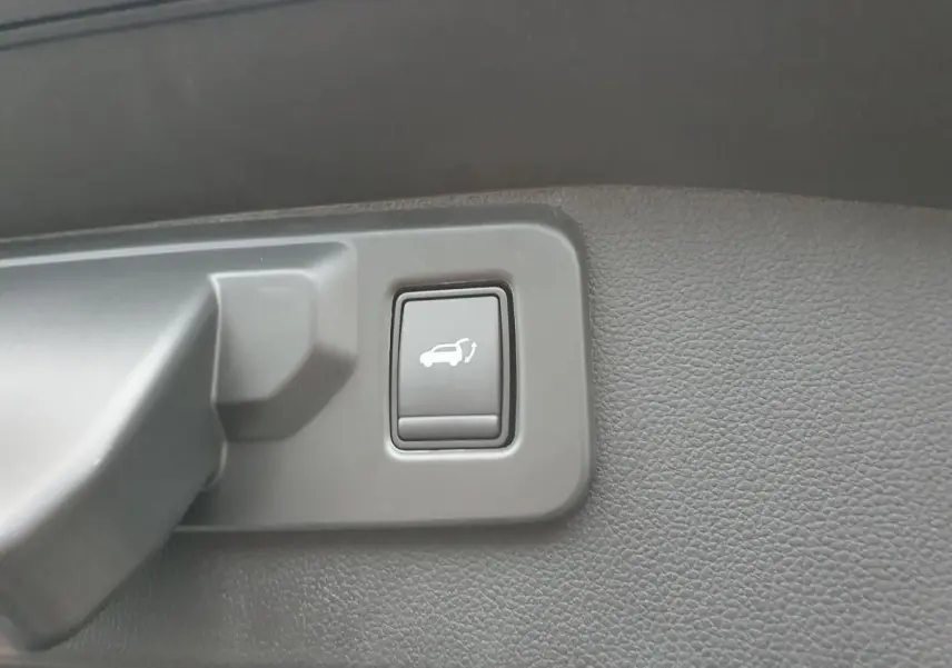 Bouton d'ouverture électrique du hayon sur panneau intérieur gris foncé du Renault Austral 2025.