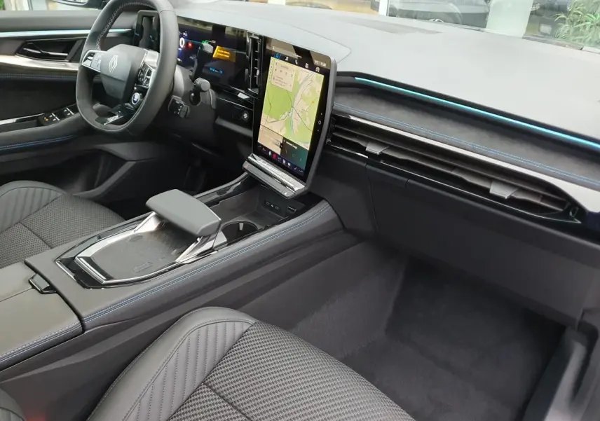Intérieur Renault Austral 2025, vue côté conducteur, tableau de bord noir avec écran tactile vertical et surpiqûres bleues.