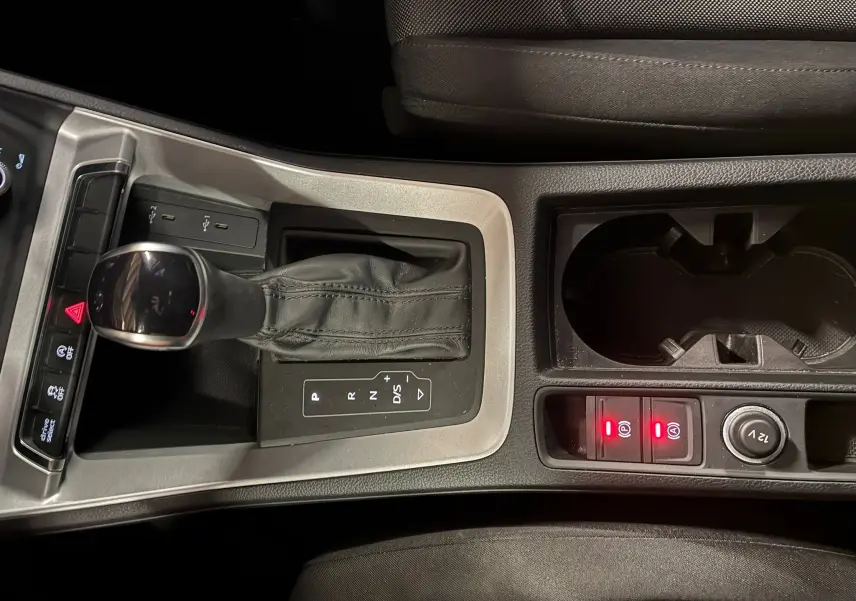 Vue rapprochée de la console centrale de l'Audi Q3 Sportback 2021, avec levier de vitesse cuir et commandes éclairées.