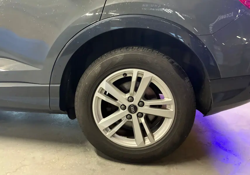 Gros plan sur la roue arrière droite gris métallisé d’un Audi Q3 Sportback avec jante aluminium 17 pouces à 5 branches doubles.