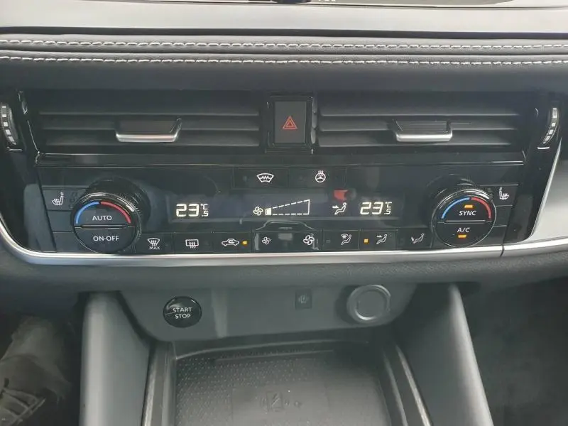 Vue rapprochée de la console centrale du Nissan Qashqai Hybrid e-POWER 2026 avec commandes de climatisation bi-zone et bouton Start/Stop.
