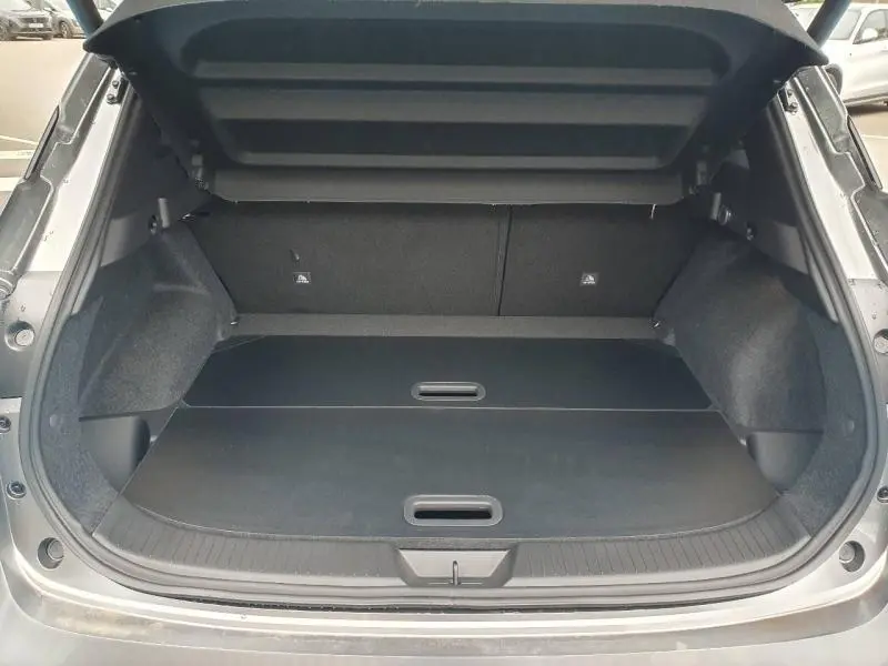 Coffre ouvert vu de l'arrière du Nissan Qashqai gris Squale Métallisé avec plancher de coffre modulable et habillage intérieur noir.