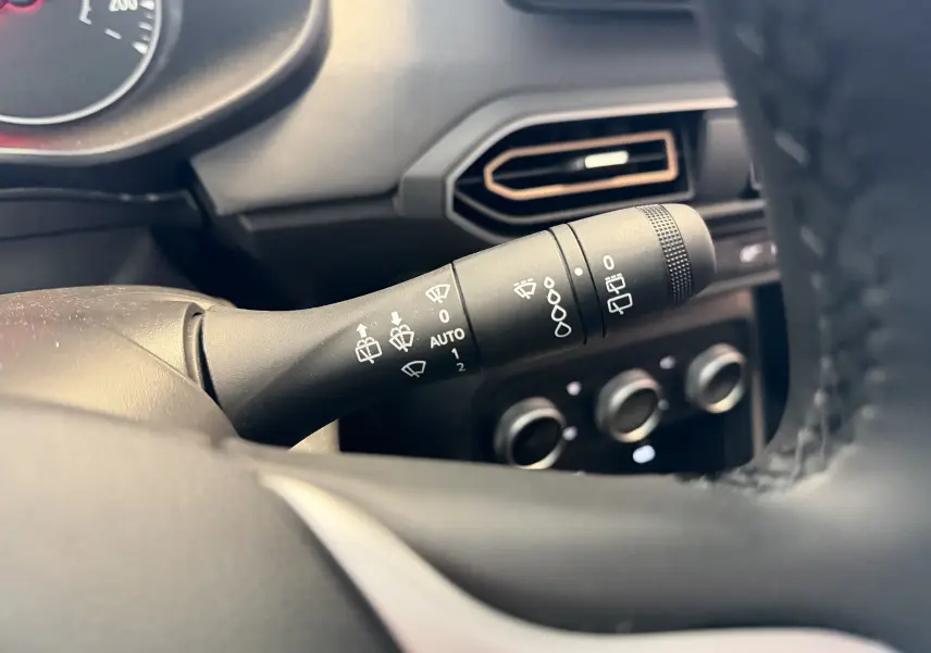Gros plan sur la commande d’essuie-glace à gauche du volant dans l’habitacle noir du Dacia Jogger 2026.
