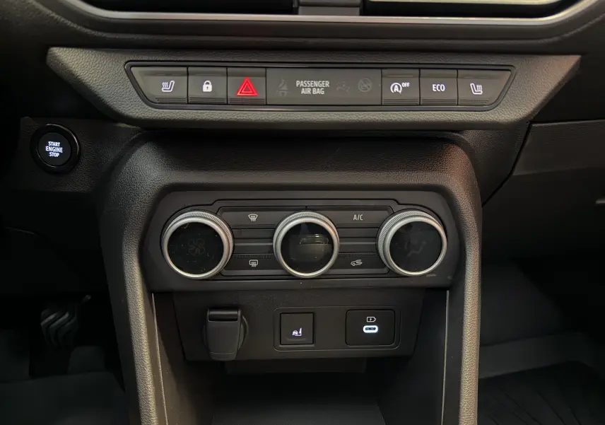 Vue rapprochée de la console centrale noire du Dacia Jogger 2026 avec commandes climatisation et bouton Start Engine Stop.