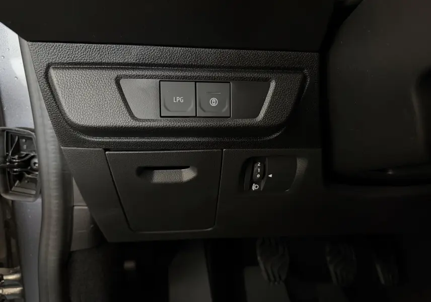 Vue rapprochée du tableau de bord côté gauche avec boutons LPG et verrouillage sur Dacia Jogger gris schiste métal.