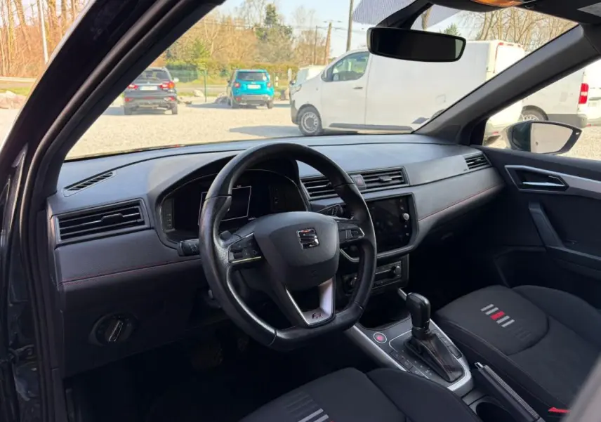 Vue intérieure côté conducteur du SEAT Arona noir 2020, avec volant multifonction et console centrale de boîte automatique.