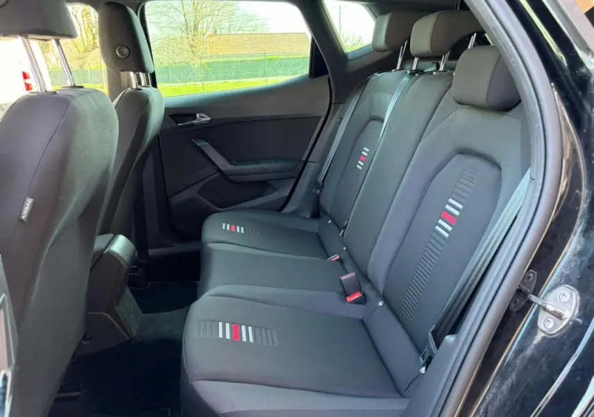 Vue intérieure côté droit des sièges arrière noirs du SEAT Arona 2020 avec motifs gris et rouges sur les assises.