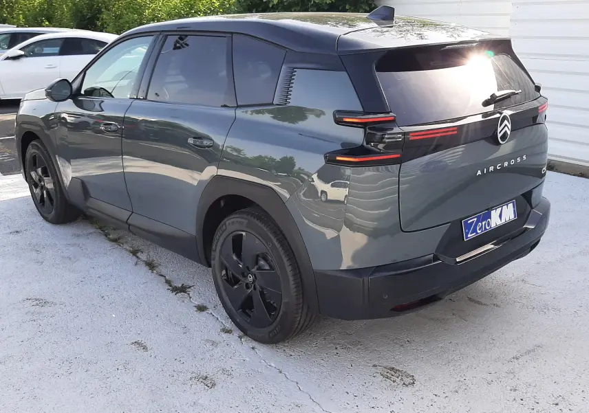 Vue 3/4 arrière gauche d'un Citroën C5 Aircross vert Astoria avec toit noir et feux arrière LED distinctifs.