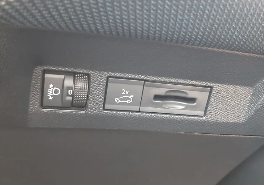 Gros plan sur les commandes intérieures du hayon électrique et réglage des phares du Citroën C5 Aircross hybride.