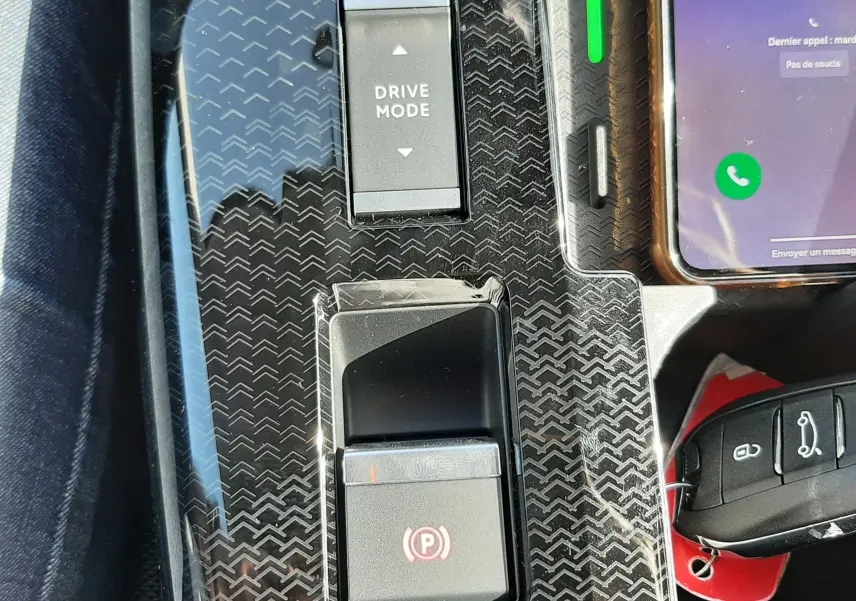 Gros plan sur la console centrale du Citroën C5 Aircross hybride 2026 avec bouton Drive Mode et frein à main électronique.