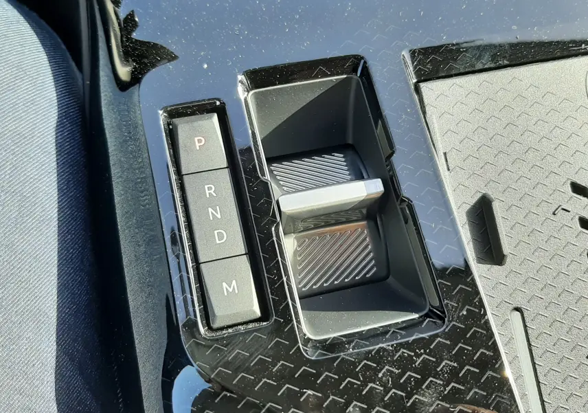 Gros plan sur la console centrale du Citroën C5 Aircross hybride 2026, avec levier de vitesses automatique et boutons de sélection P, R, N, D, M.
