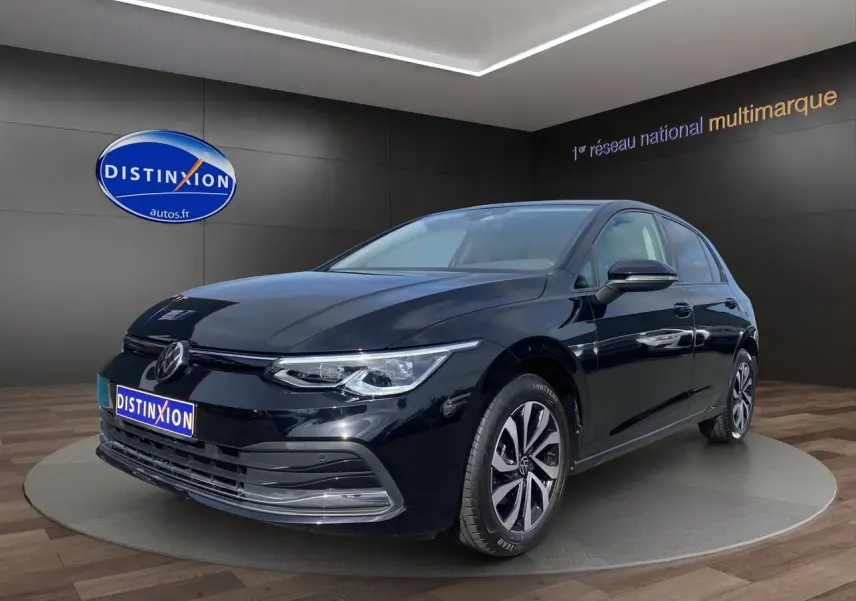 Volkswagen Golf VIII noire vue en 3/4 avant droit, avec jantes alliage et vitres surteintées dans un showroom.