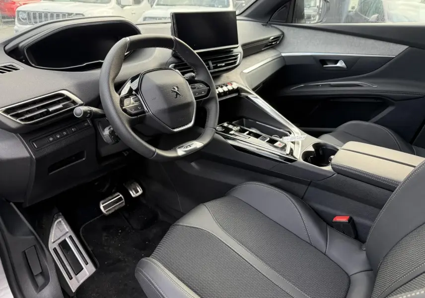 Intérieur avant droit Peugeot 3008 Hybrid 2023 avec volant cuir GT, console centrale moderne et sellerie noire Mistral.