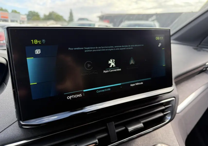 Écran tactile central du Peugeot 3008 Hybrid 2023 affichant les options de connectivité dans un intérieur gris.