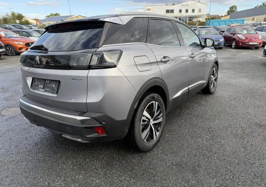 Vue 3/4 arrière droite d'un Peugeot 3008 Hybrid gris métallisé avec jantes bi-ton et vitres arrière surteintées.