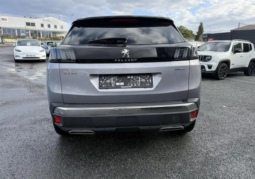 Vue arrière d'un Peugeot 3008 Hybrid gris métallisé avec feux arrière LED 3D et double sortie d'échappement chromée.