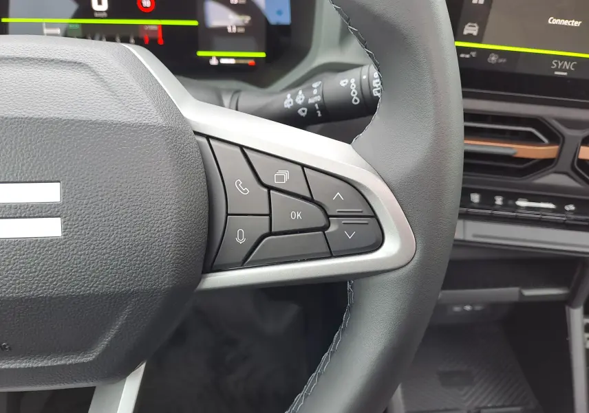 Vue rapprochée du côté droit du volant du Dacia Bigster 2025, avec commandes multifonctions et tableau de bord numérique.