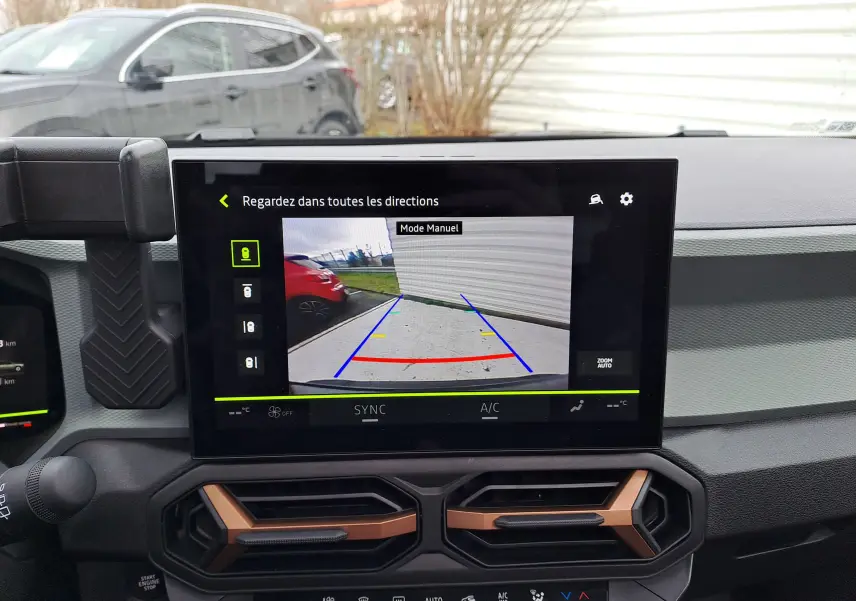 Vue intérieure du tableau de bord du Dacia Bigster noir nacré 2025, avec écran central affichant la caméra de recul en mode manuel.