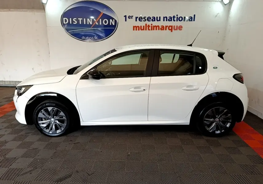 Peugeot 208 électrique blanche vue de profil côté gauche, avec jantes foncées et logo "e" arrière.