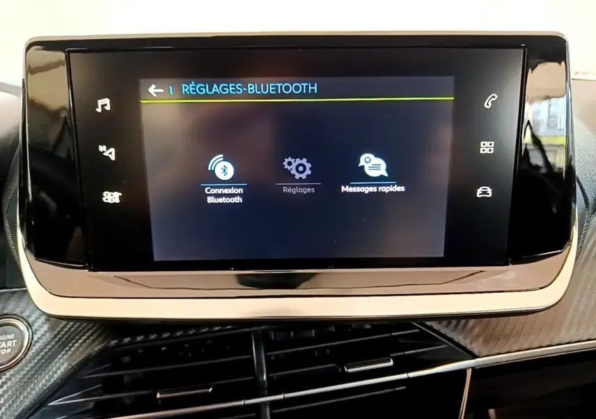 Écran tactile central affichant les réglages Bluetooth dans l’habitacle d’une Peugeot 208 électrique blanche.